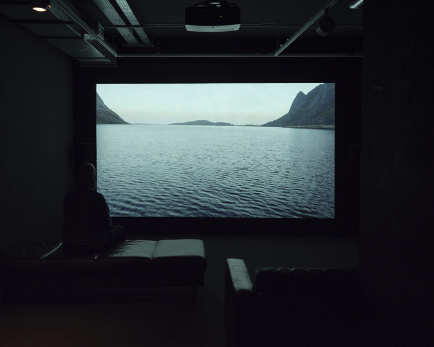 ciemna sala z projekcją wideo na której widać duży zbiornik wodny