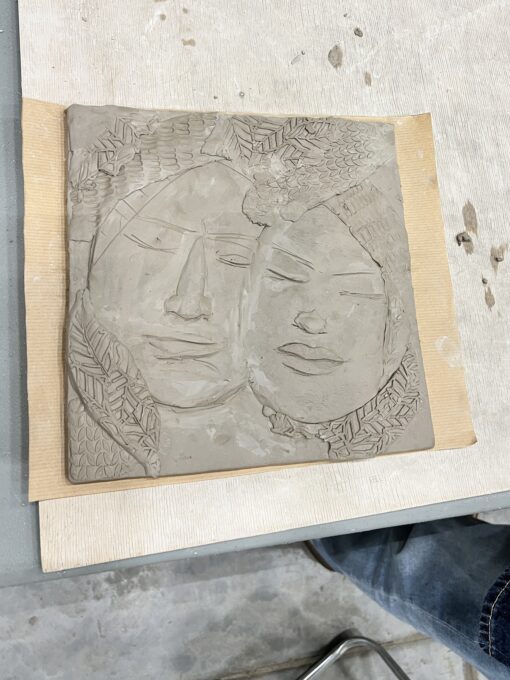 relief na glinie przedstawiający twarze dwóch osób